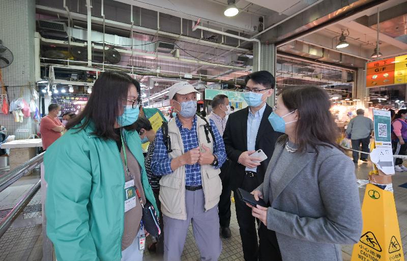 Photo shows Deputy Director of Food and Environmental Hygiene Miss Diane Wong (first right) visiting a public market this morning to learn more about the arrangement, and listening to the views of the public and trade representatives